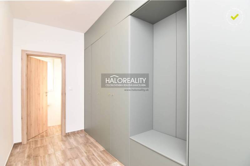 A hallway in a family house with wooden doors and built-in wardrobes.