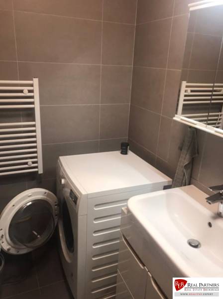 Bathroom with a washing machine and a sink in a 2-room apartment.