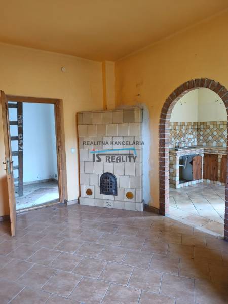 Family house with a tiled stove and an arched entrance to the kitchen, tiled flooring.