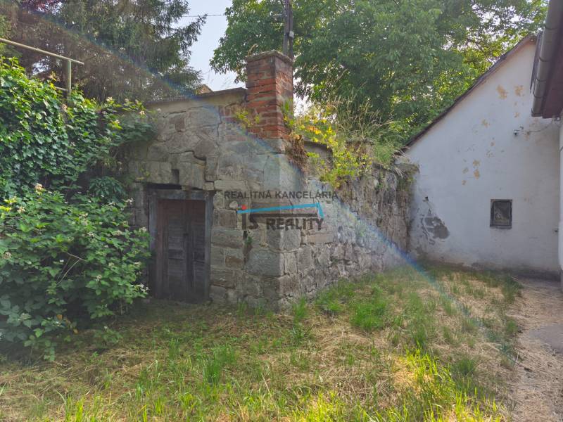 Old stone wall with a small door by the family house in Hont.