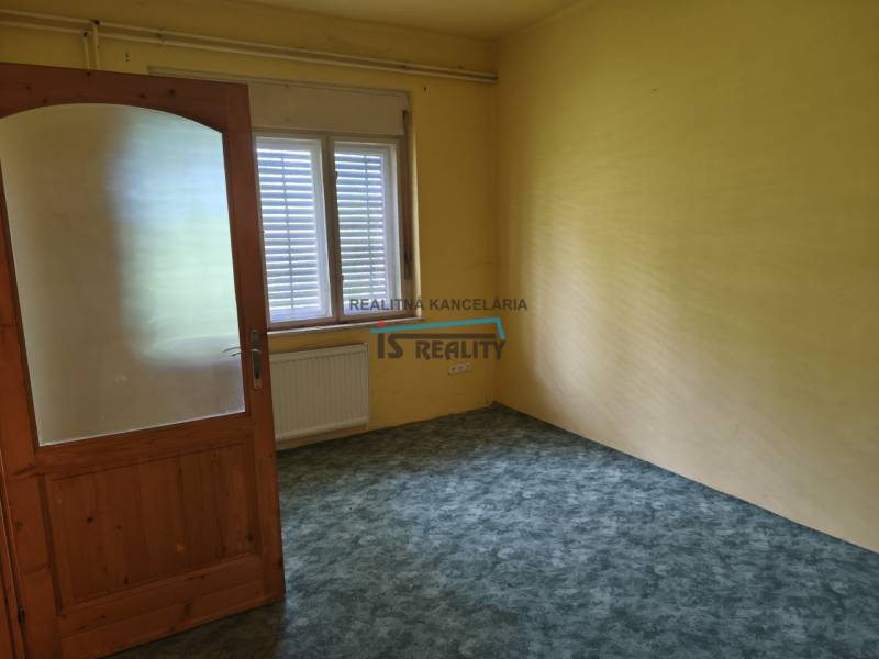 A room in a family house with yellow walls and wooden doors, suitable for rent.