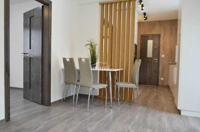 Dining area with three chairs and a table in a 3-room apartment.