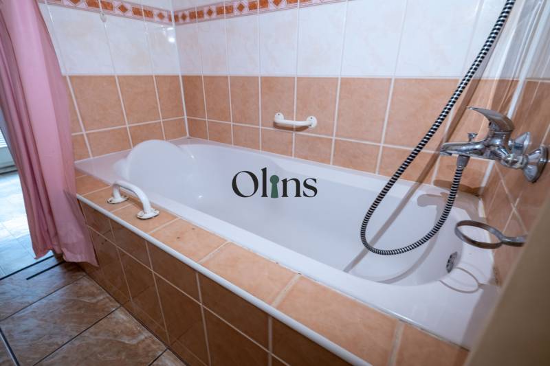 Bathroom in a 2-room apartment with a bathtub, tiled in light colors.