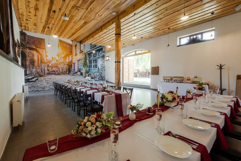 Gastro premises with a rustic ceiling, long table, and decoration for special events.