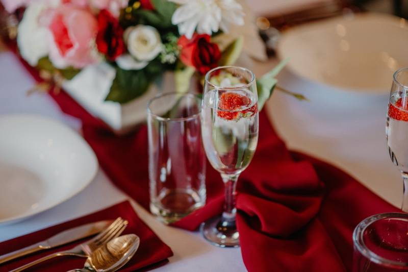 A table set with drinks and red decorations in a gastro space.