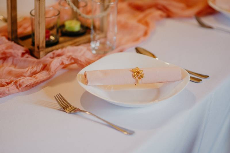 A table set with a plate, cutlery, and decorative elements in a dining area.