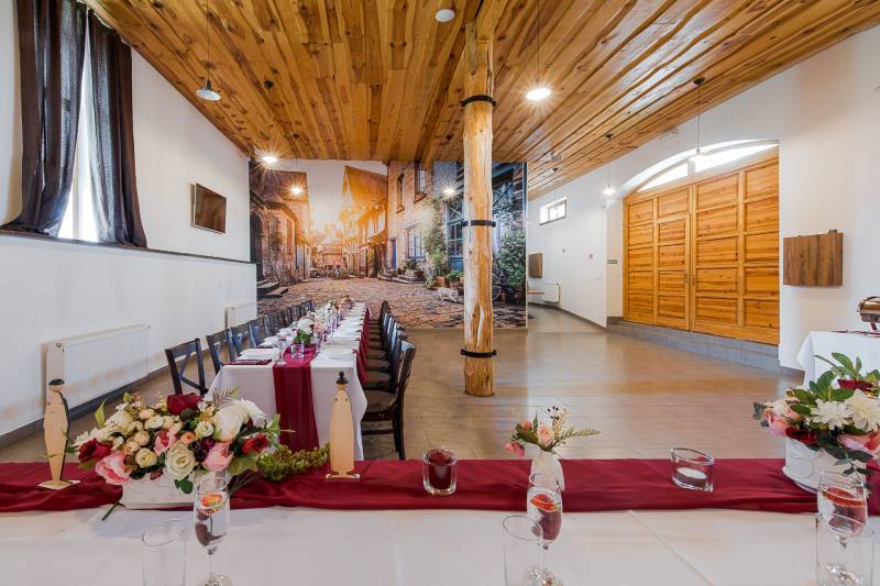 Interior of a gastro space with a decorated table and a photograph of an alley on the wall.