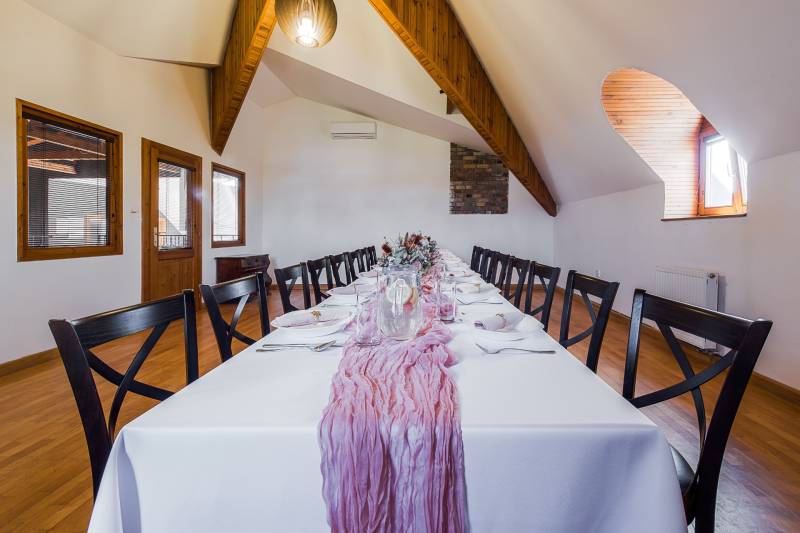 A table in interior dining spaces with prepared decorations and cutlery.