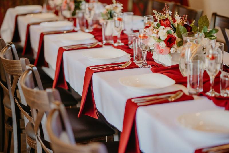 A table with red napkins, set for guests in a dining area.