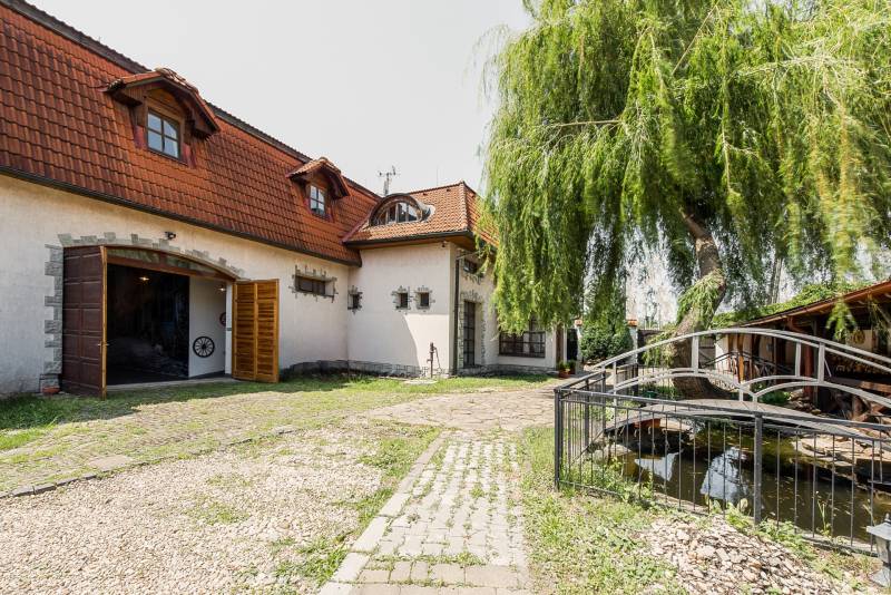 The exterior of the gastro spaces in Prešov with a bridge and a green garden.