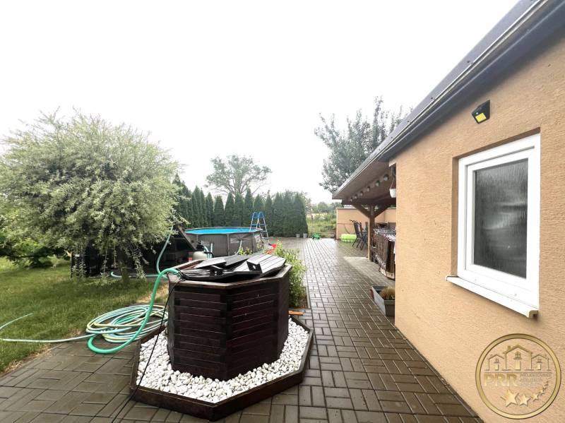 The courtyard of a family house in Veľké Chlievany with a swimming pool and a paved terrace.