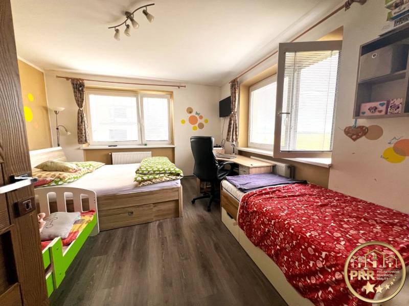 Children's room in a family house with two beds and a desk.