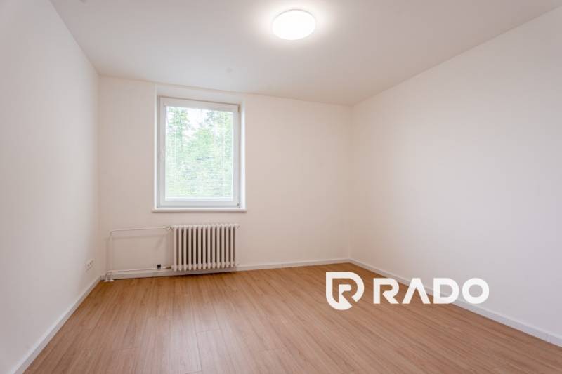 Empty room with white walls, floor, and window in a 3-room apartment.