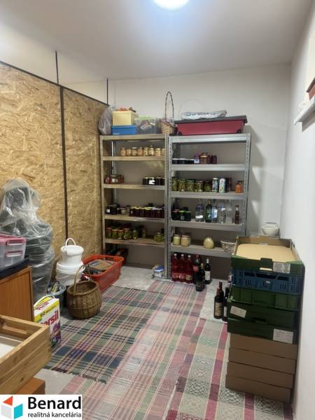 A pantry in a one-room apartment with shelves full of preserves and boxes.