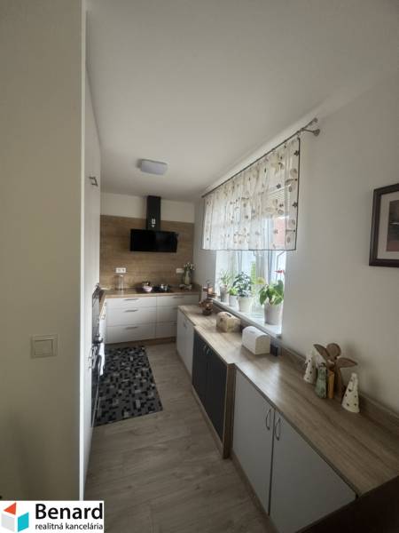 A cozy kitchen with a window and white cabinets in a studio apartment.