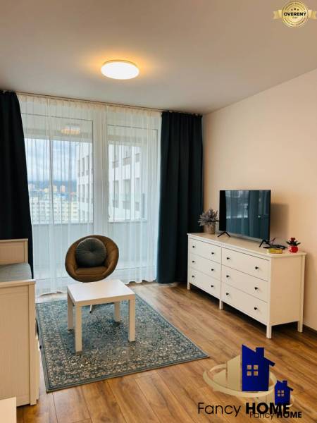 Bright living room in a one-bedroom apartment with a balcony and wooden flooring.