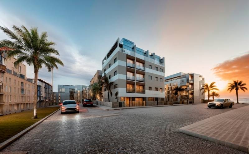 A street with palm trees and apartment buildings in San Pedro del Pinatar at sunset.