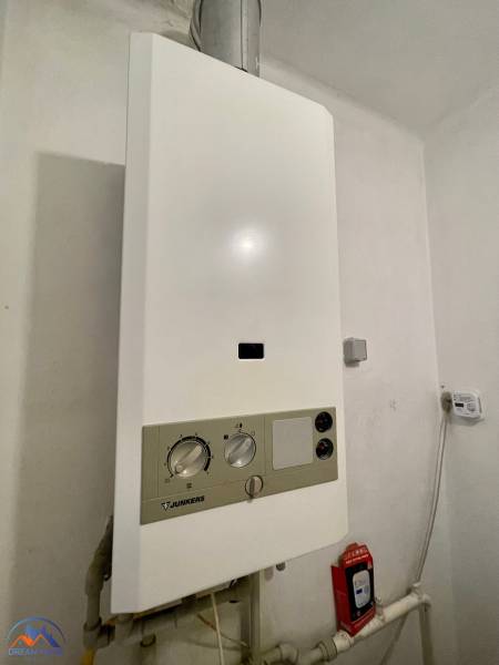 Gas boiler Junkers in the bathroom of a 3-room apartment, next to it is a carbon monoxide detector.