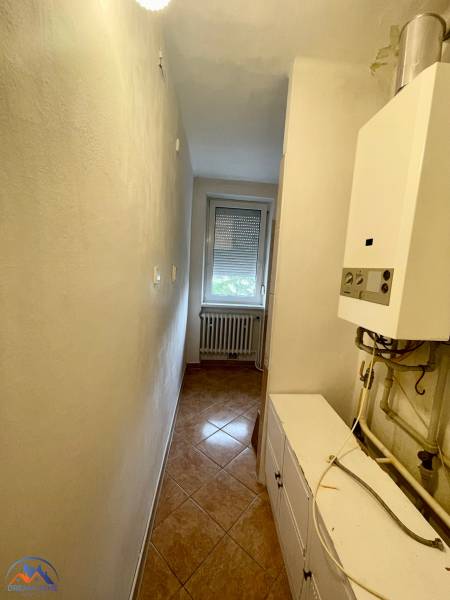 A narrow corridor with a boiler and a window in a 3-room apartment.