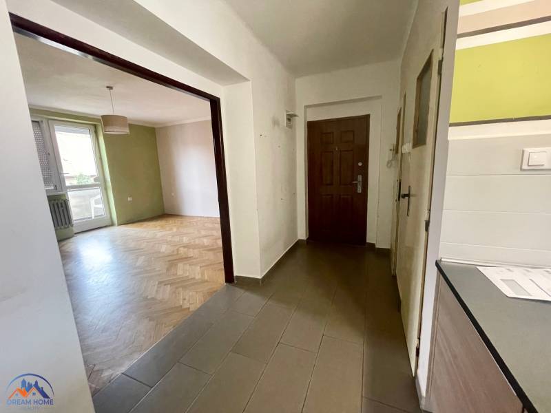 Entrance hallway with wooden flooring and an open passage to the living room in a 3-room apartment.