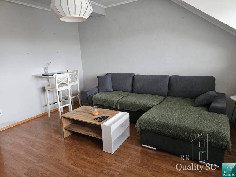 Living room with a sofa and a stool in a 3-room apartment.