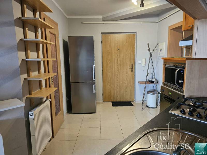 A kitchen in a 3-room apartment with a stainless steel refrigerator and modern appliances.