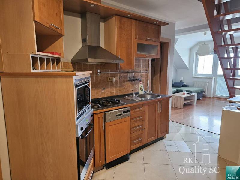 Kitchen and living area with staircase in a 3-room apartment.