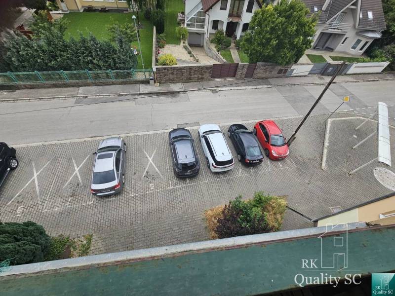 Parking lot on Kysucká Street in Senec with five parked cars near a 3-bedroom apartment.