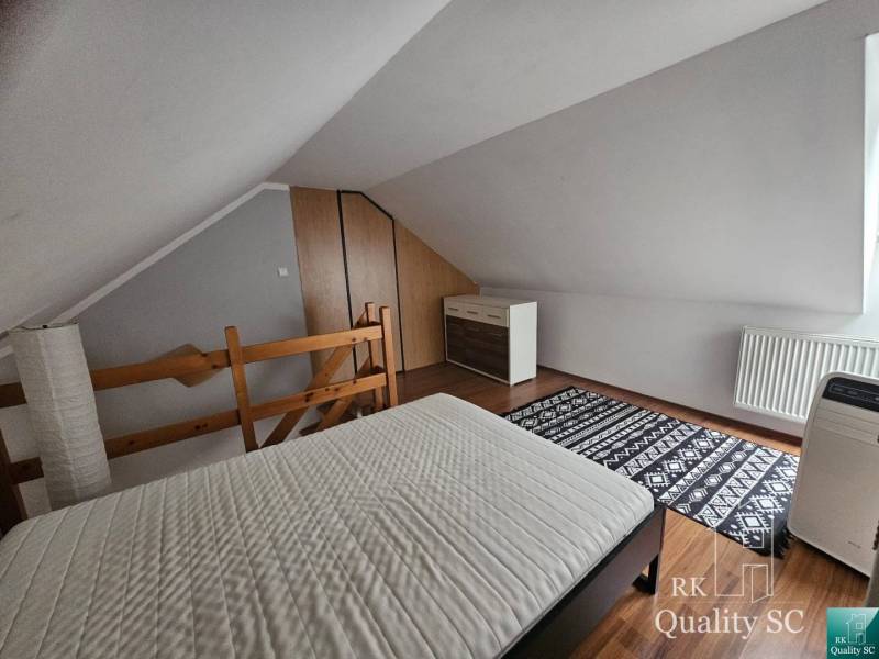 Attic room in a 3-room apartment with a bed, dresser, and carpet.