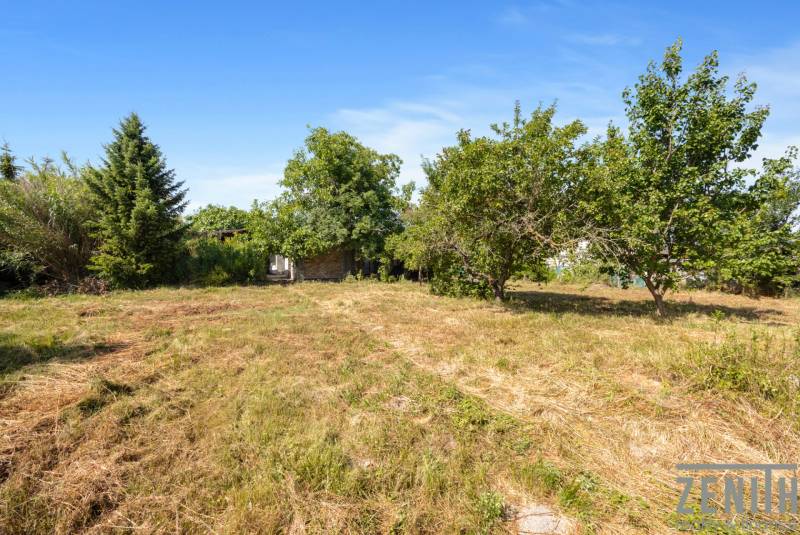 A plot in Dobrohošť, ideal for living, surrounded by trees and greenery.