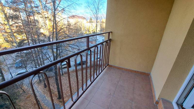 Balcony on Štúrova Street in Poprad, view of trees and a parking lot.