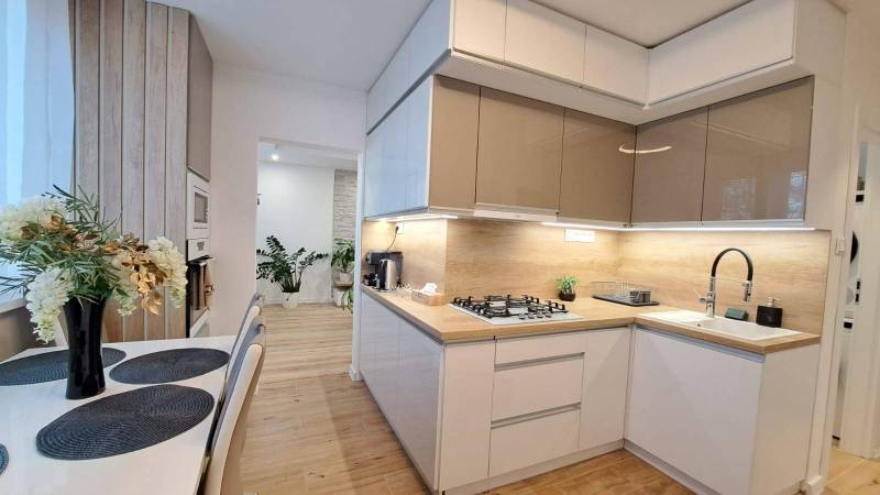 A kitchen in a 2-room apartment with a dining table and wooden elements.