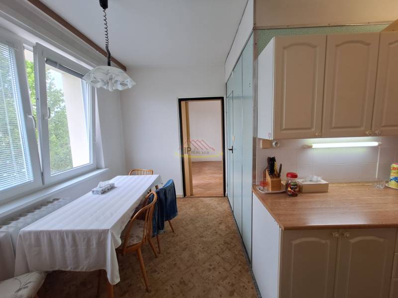 A bright kitchen with a dining table and a window in a 3-room apartment.