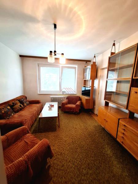 Living room in a 3-room apartment with cream furniture and carpeted flooring.