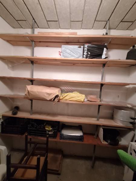 Shelf storage space in a 3-room apartment with wooden shelves and various items.
