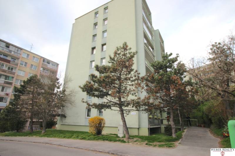 Apartment building on Na Revíne Street in Bratislava - Kramáre, surrounded by trees.