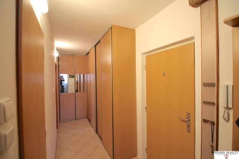 A hallway with built-in wardrobes and wooden doors in a 3-room apartment.