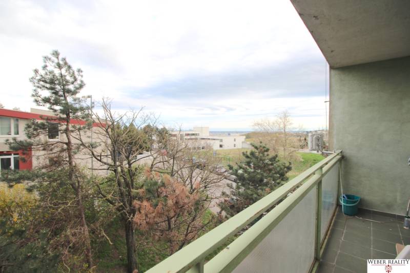 A balcony with a view of nature and urban development in Bratislava on Na Revíne Street.