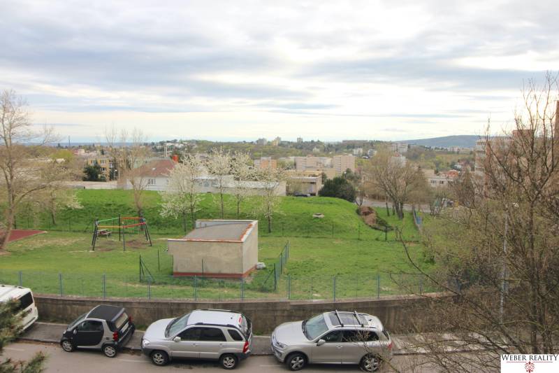 View of the playground and greenery from a 3-room apartment on Na Revíne Street in Bratislava.