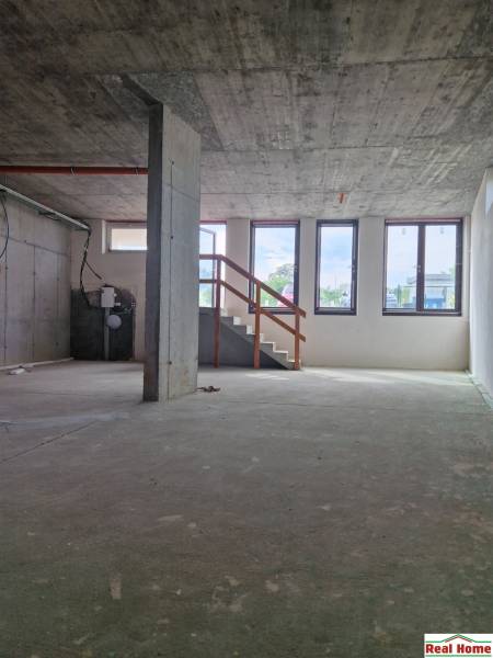 Concrete interior of gastro spaces with a staircase and large windows.