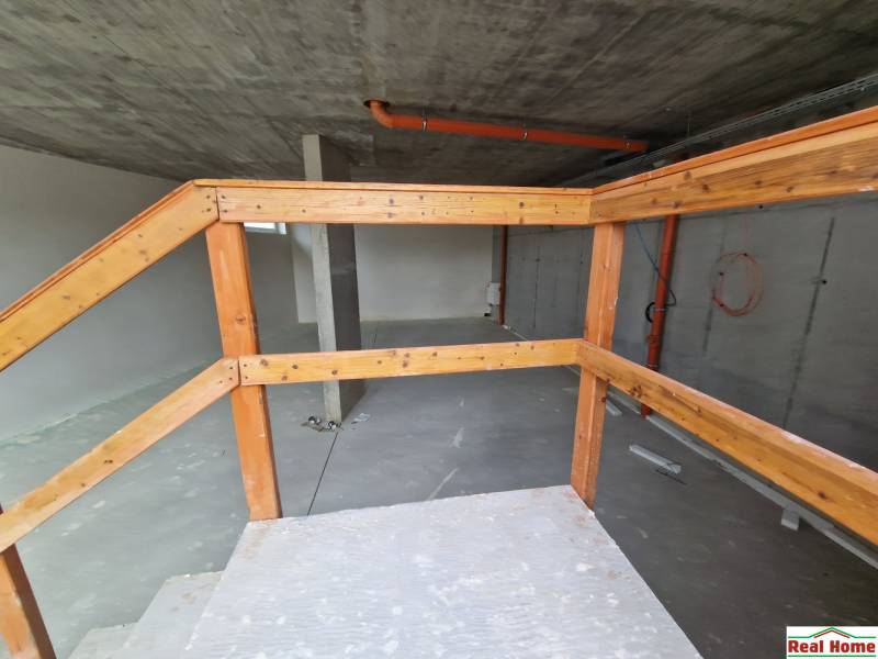 Construction of gastro spaces with wooden railings and a concrete ceiling.