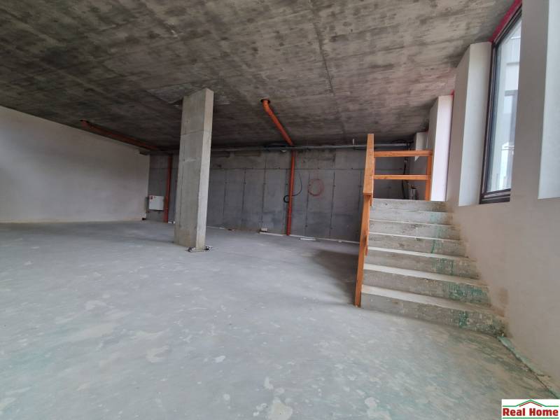 Empty interior of gastro spaces with stairs and a concrete pillar.