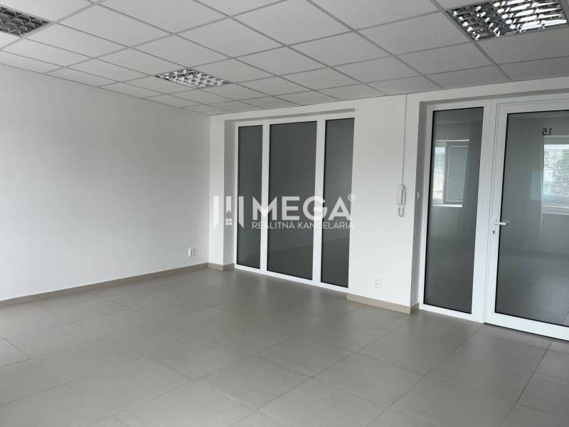 A spacious office with tiles and glass doors, suitable for various purposes.