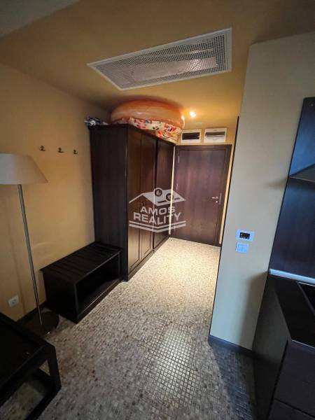 Entrance hallway in a holiday apartment with dark furniture and modern lighting.