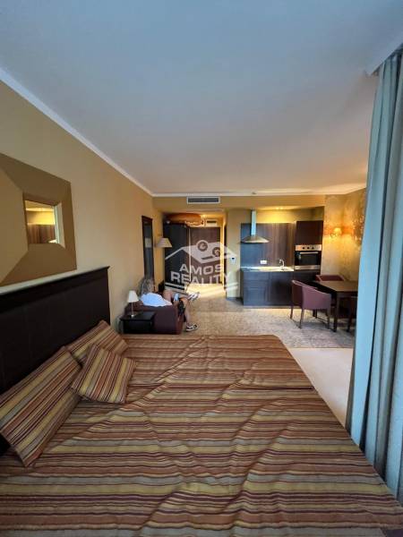A bedroom in a holiday apartment with a kitchenette and comfortable furniture.