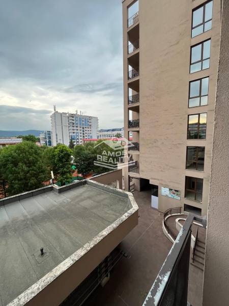 View from a holiday apartment in Sunny Beach with modern buildings and trees.