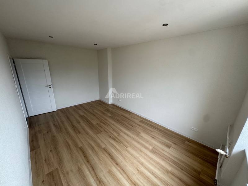 A spacious room with laminate flooring and white walls in a 2-room apartment.