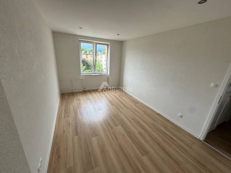 An empty room with a wooden floor and a window in a two-room apartment.