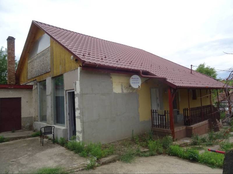 A family house in Leh with a red roof and a satellite dish.