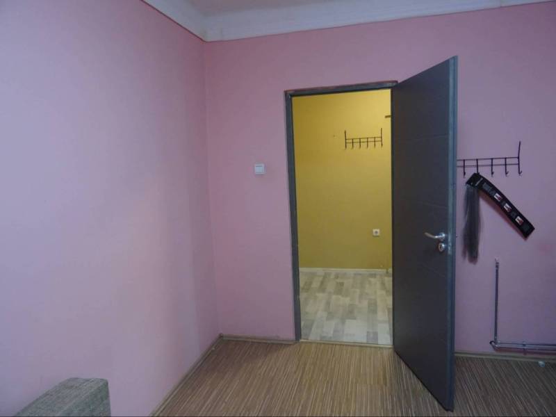 The interior of a family house with pink walls and open doors to another room.